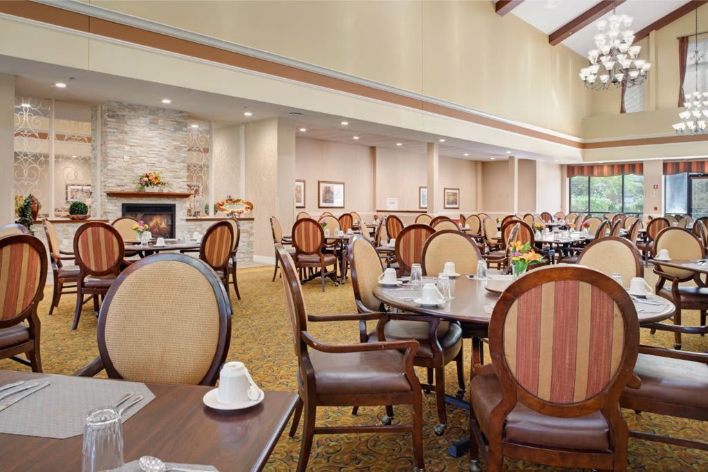 An elegantly decorated dining area featuring multiple tables and chairs, ready for guests.