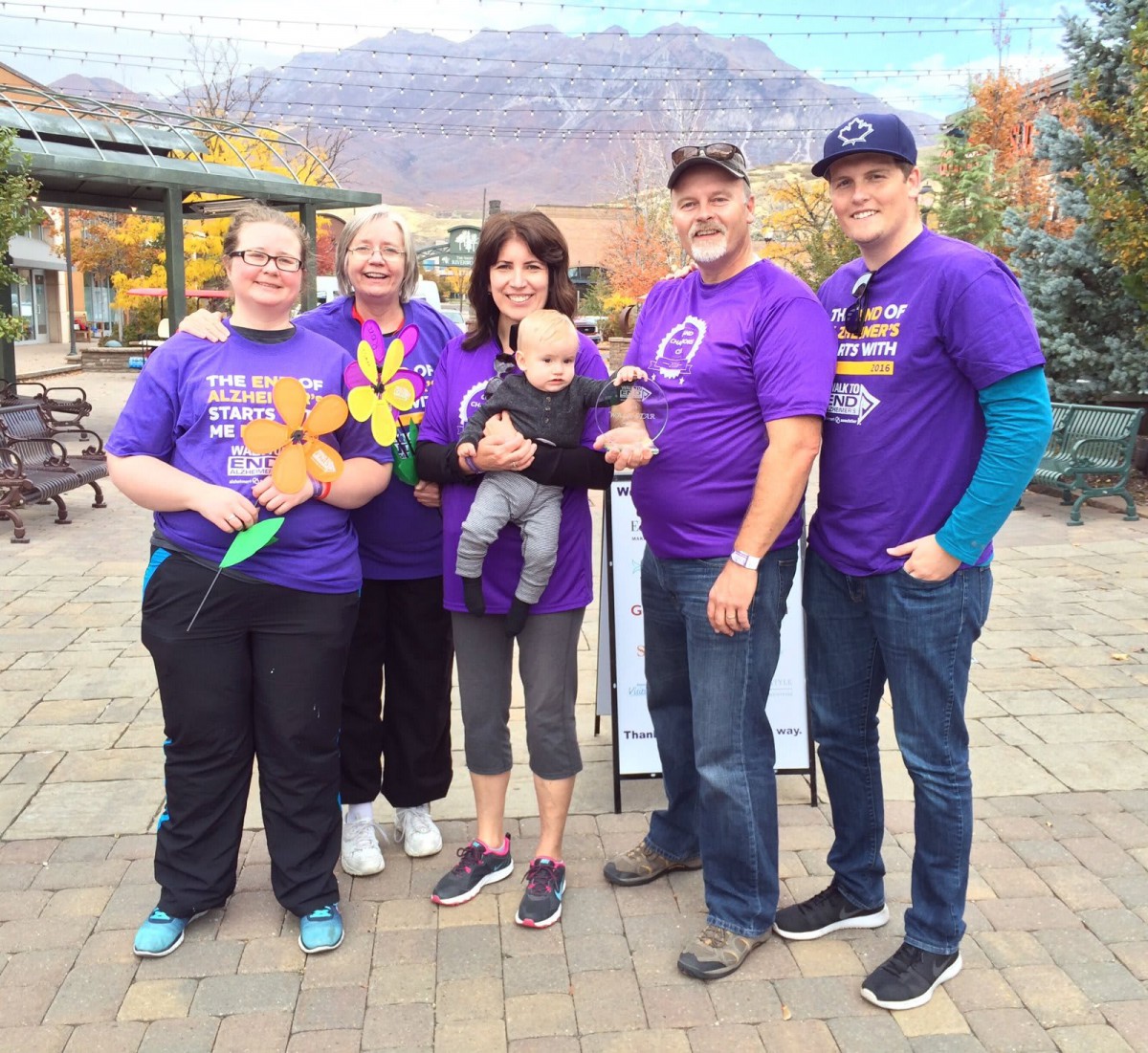 A group of people wearing purple shirts posing together outdoors.