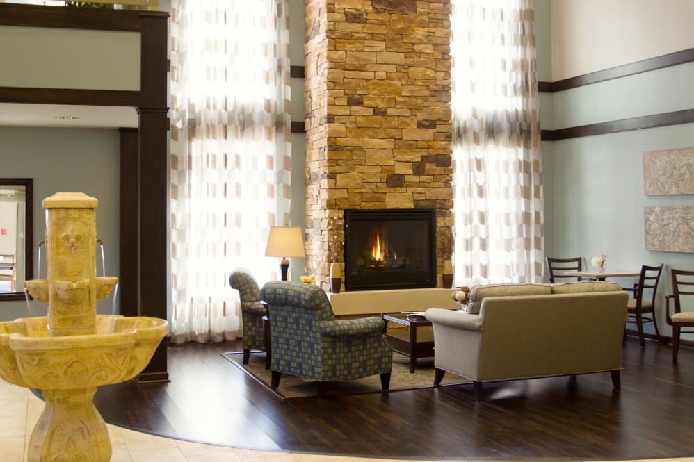 A cozy living room with a stone fireplace and comfortable seating.
