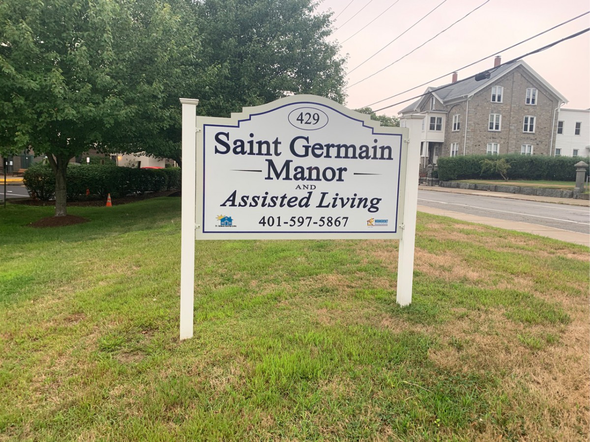 A sign for Saint Germain Manor Assisted Living located outdoors near a building.