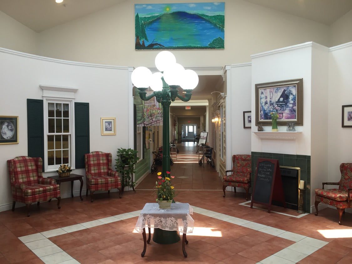 A well-decorated lobby featuring a chandelier, elegant furniture, and art on the walls.