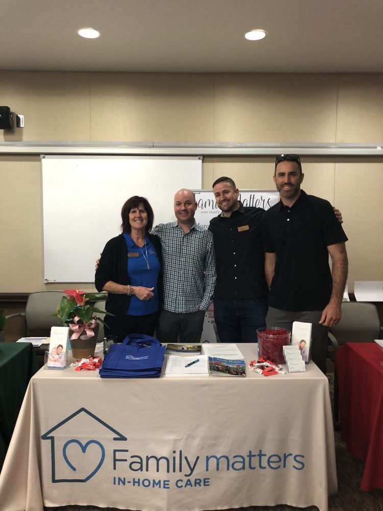 A group of people standing behind a booth at an event.