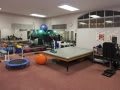 A rehabilitation room equipped with various exercise tools and therapy equipment.