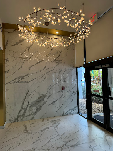 A stylish lobby featuring elegant marble walls and decorative lighting.