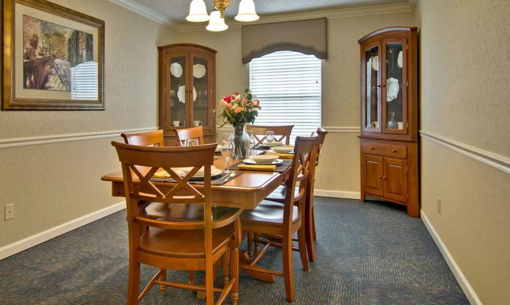 A cozy dining room with a wooden table, chairs, and cabinets showcasing elegant interior design.