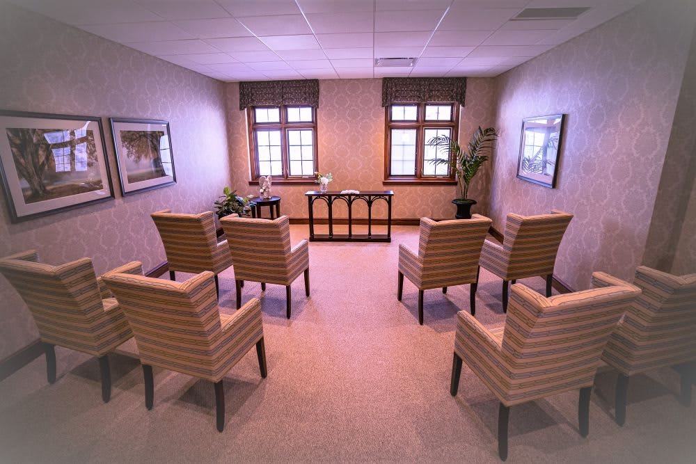 A therapy room with a circular seating arrangement of chairs, designed for group meetings.