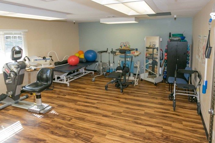A fitness room equipped with various exercise machines and therapy equipment.