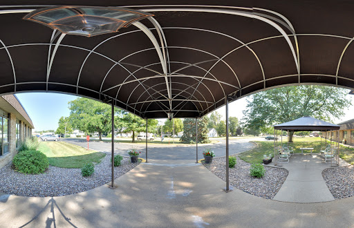 A view of a spacious outdoor canopy structure surrounded by greenery.