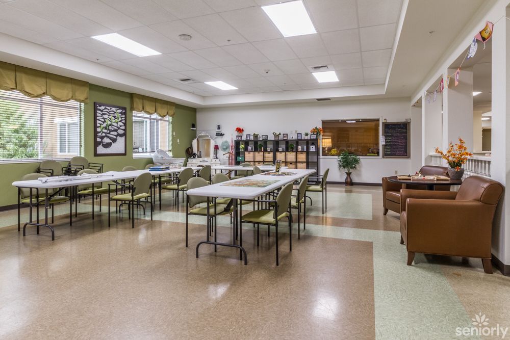 An empty classroom or meeting room with arranged tables and chairs, ready for use.