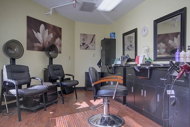 A well-lit hair salon with stylish chairs and artwork on the walls.