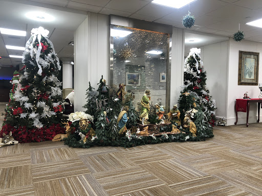 A beautifully decorated holiday display featuring multiple Christmas trees and a festive nativity scene.