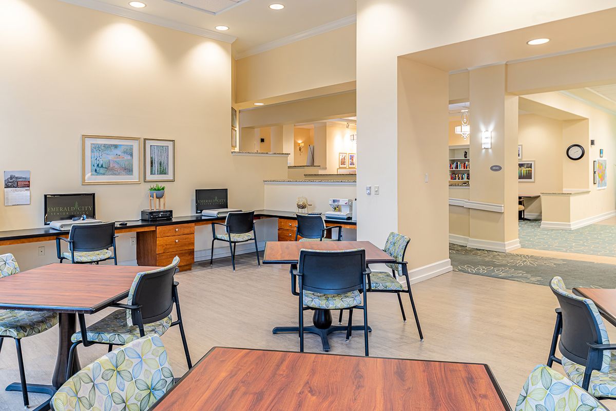 A modern office space with multiple desks and chairs, featuring computer stations and a bright, welcoming atmosphere.