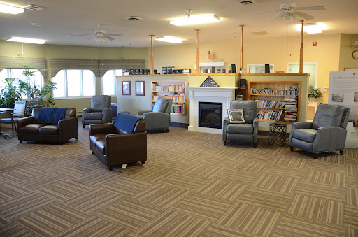 A cozy reading area in a library featuring comfortable seating and bookshelves.