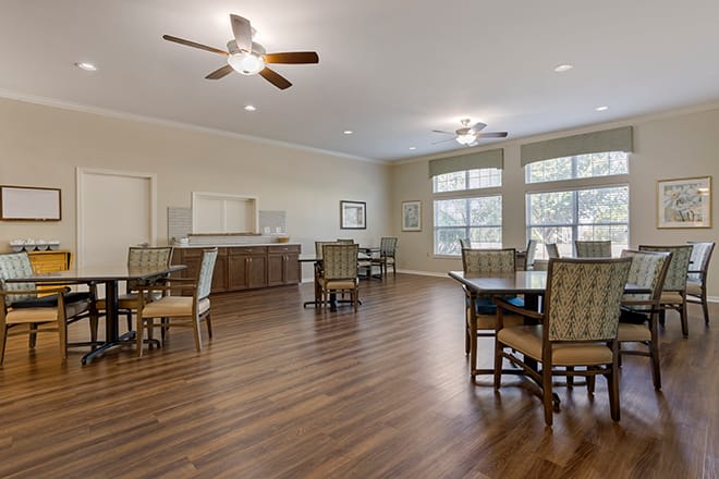 A spacious and modern dining area with wooden floors, tables, and chairs.