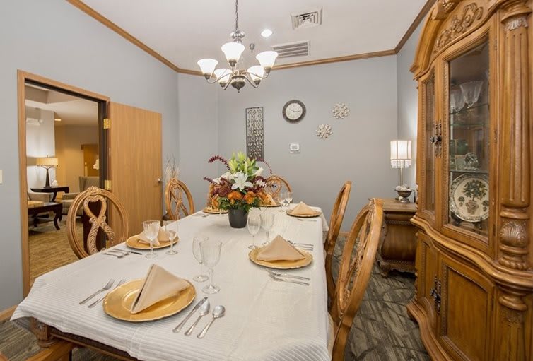A neatly arranged dining room with a long table, chairs, and elegant decorations.