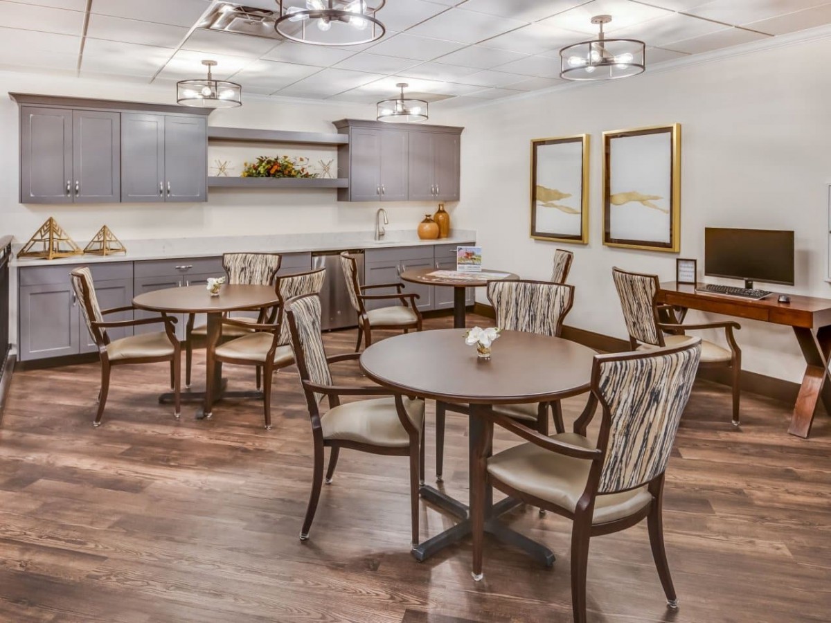 A modern dining area with wooden tables and chairs, stylish light fixtures, and a sleek interior design.