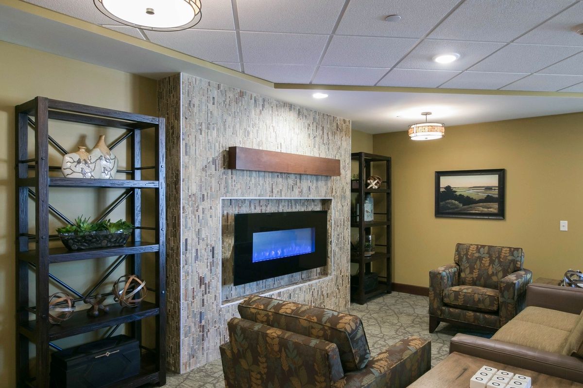 A modern living room with a sleek electric fireplace and comfortable seating.