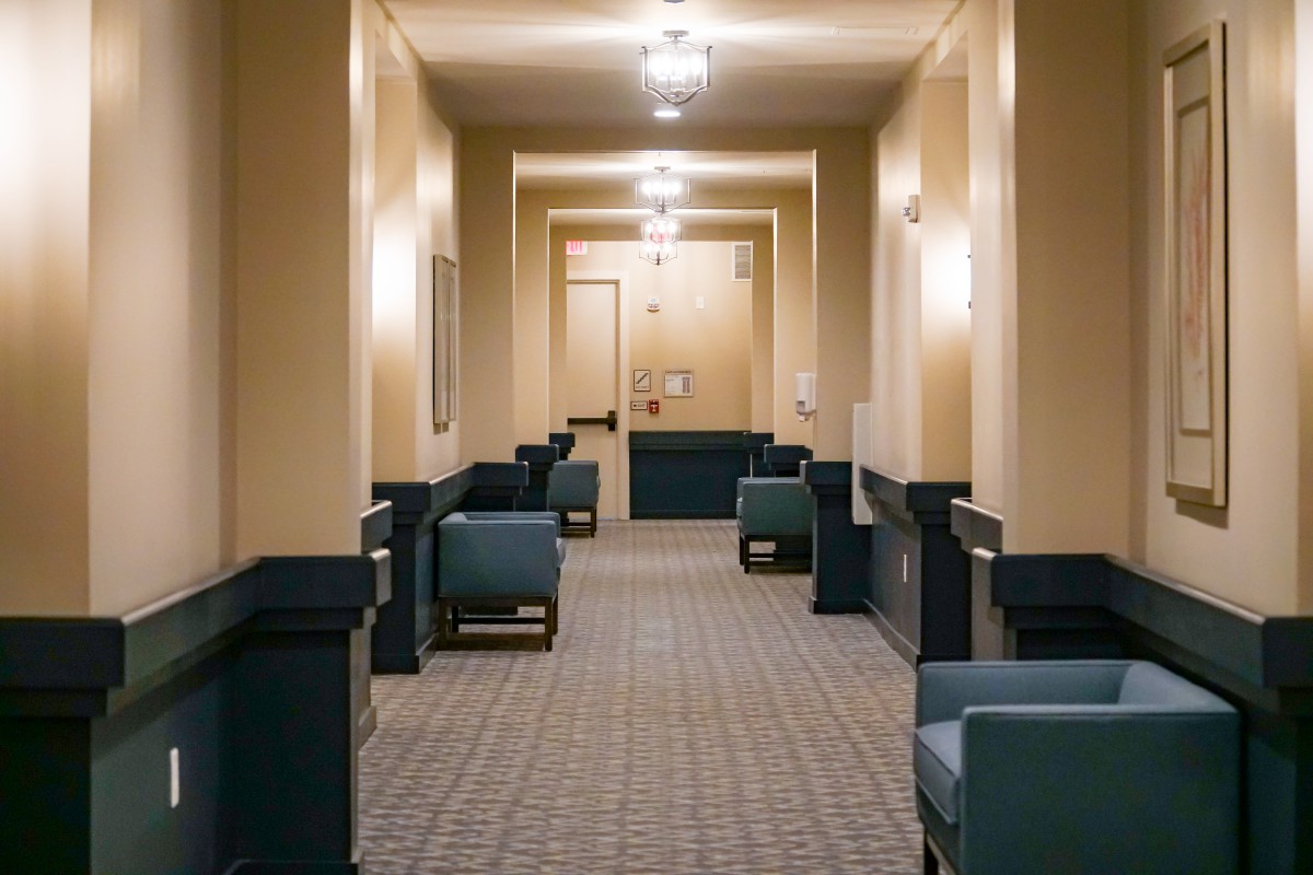 A well-lit hallway with seating arrangements on both sides.