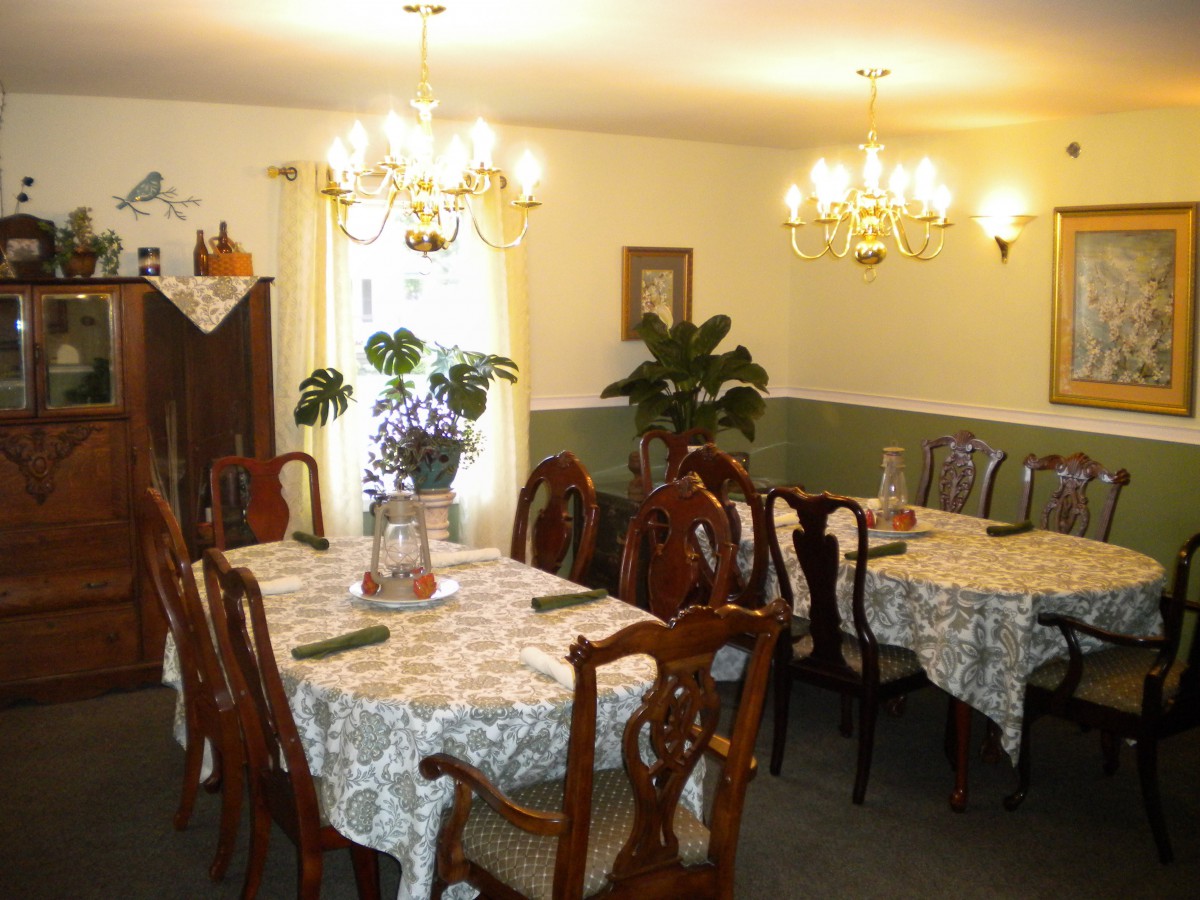 A cozy dining room with elegantly set tables and chandeliers.