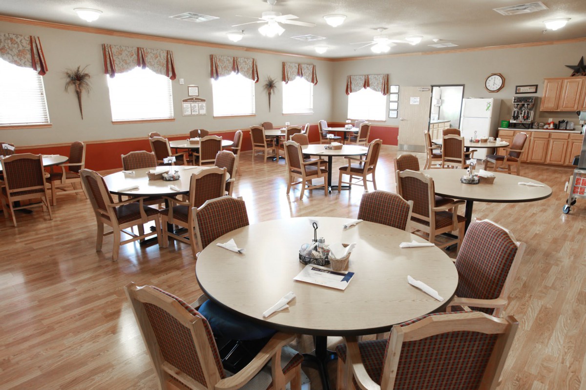 An empty dining room with neatly arranged tables and chairs.