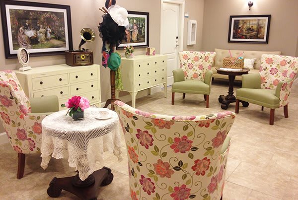 A vintage-themed living room with floral patterned chairs and elegant decor.