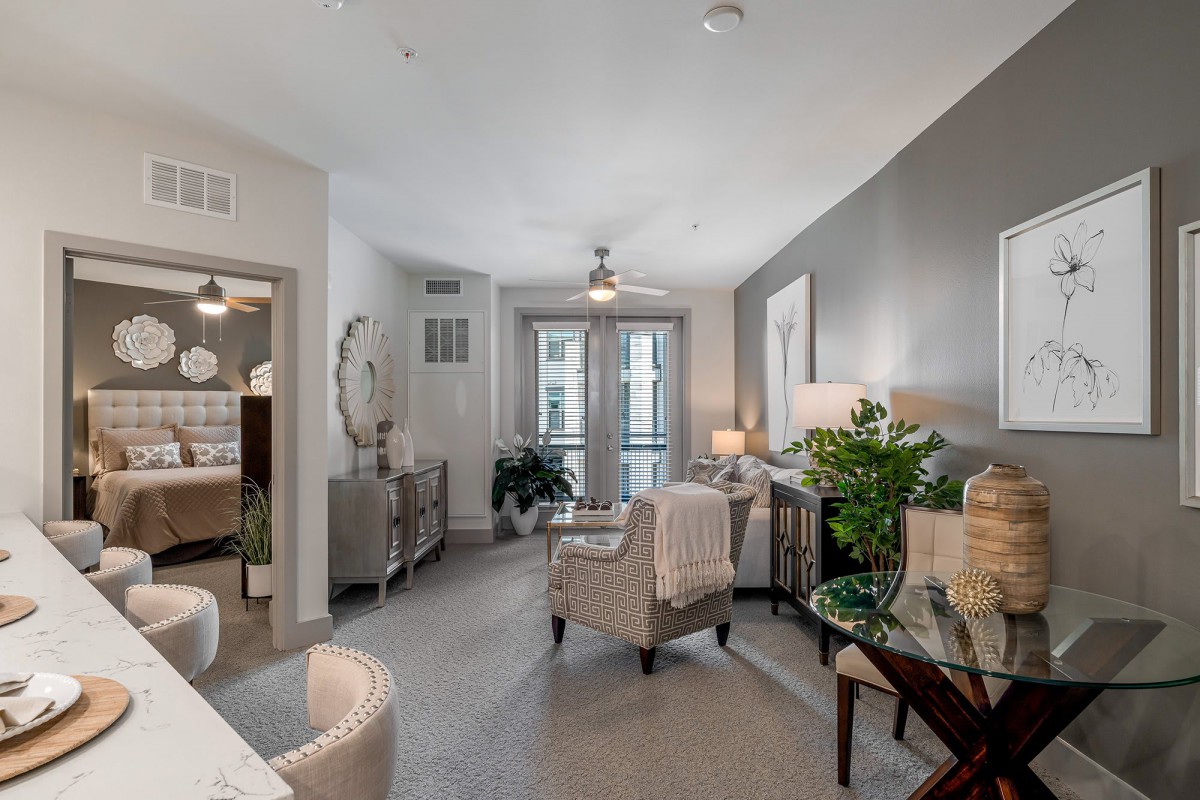 A modern living room with neutral colors, stylish furniture, and decorative plants.