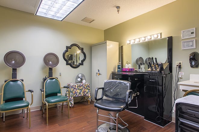 A cozy hair salon interior with a styling chair and vanity mirror.
