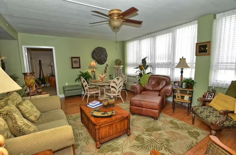 A cozy living room with comfortable seating, lush plants, and tasteful decor.