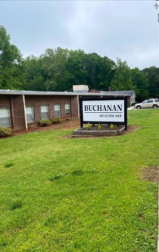 View of the Buchanan sign in front of a building, surrounded by grass and trees.