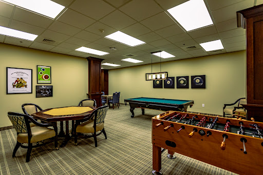 A well-lit recreation room featuring a pool table and a foosball table, perfect for leisure activities.
