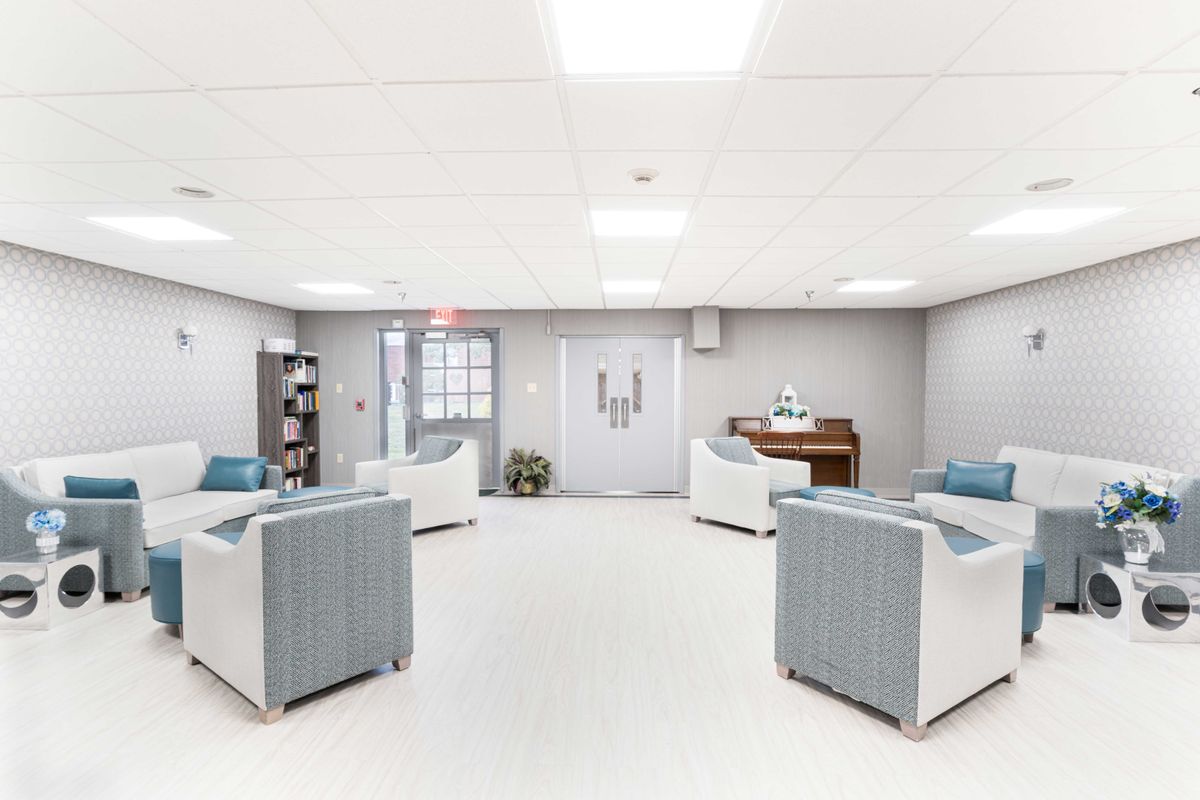 A modern waiting room with comfortable seating and a piano.