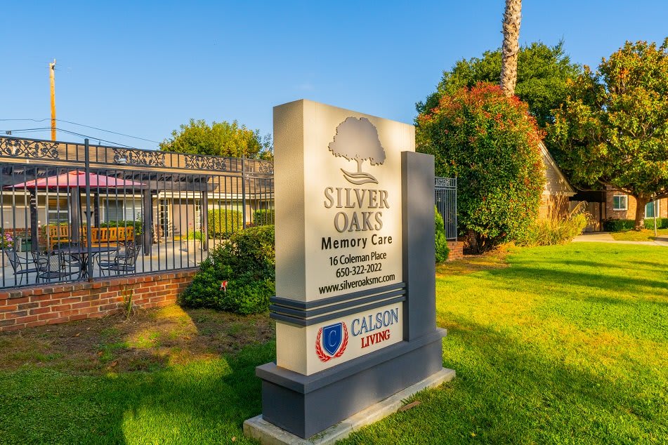 Sign for Silver Oaks Memory Care facility set against a landscaped outdoor area.