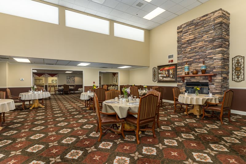 A spacious dining area with elegantly set tables and a warm, inviting atmosphere.