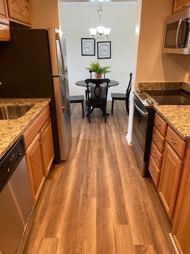 A modern kitchen featuring granite countertops and a dining area.