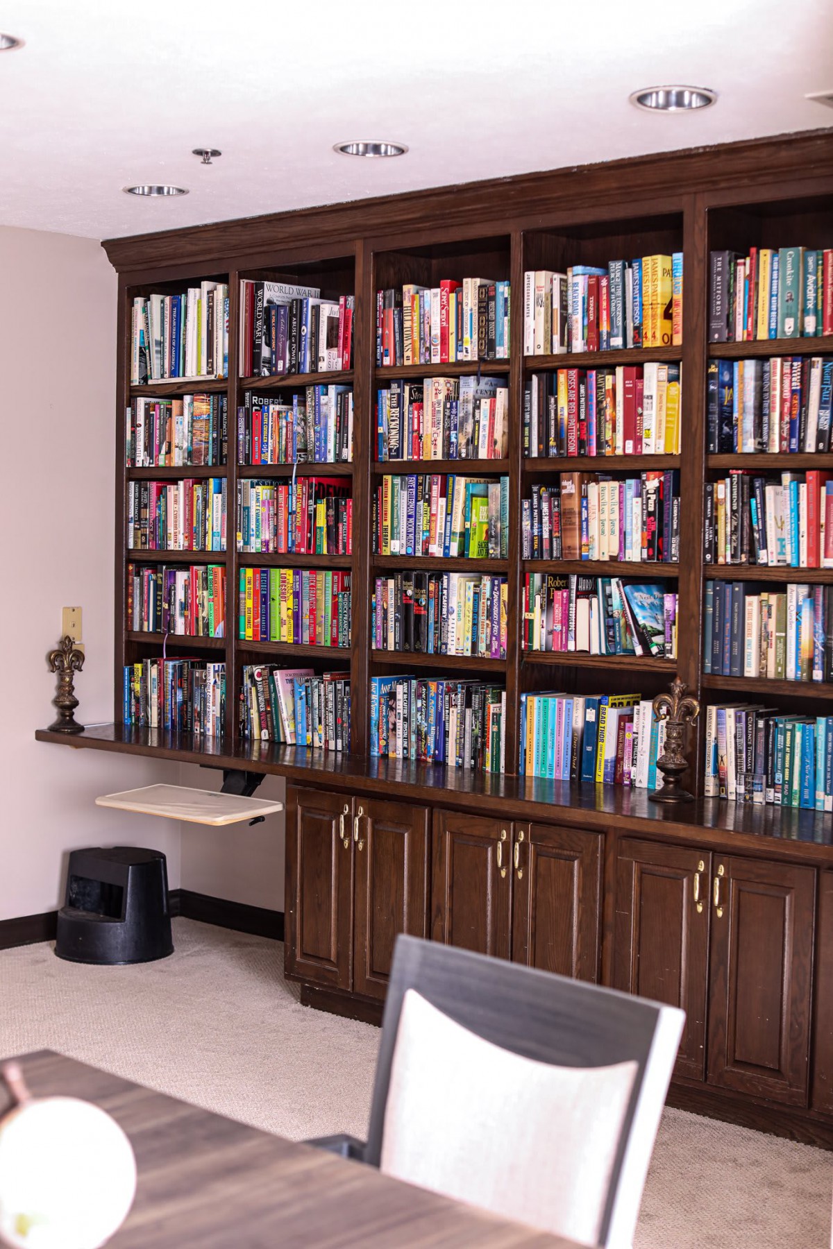 A well-organized bookshelf filled with a variety of books in a home office setting.