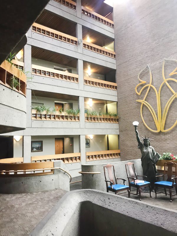 A modern atrium featuring multiple balconies and a prominent statue.