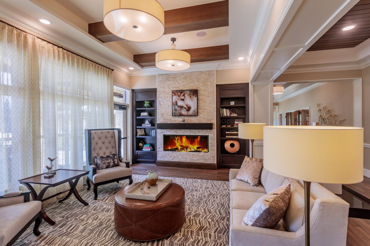 A modern and cozy living room featuring a fireplace, elegant furniture, and soft lighting.
