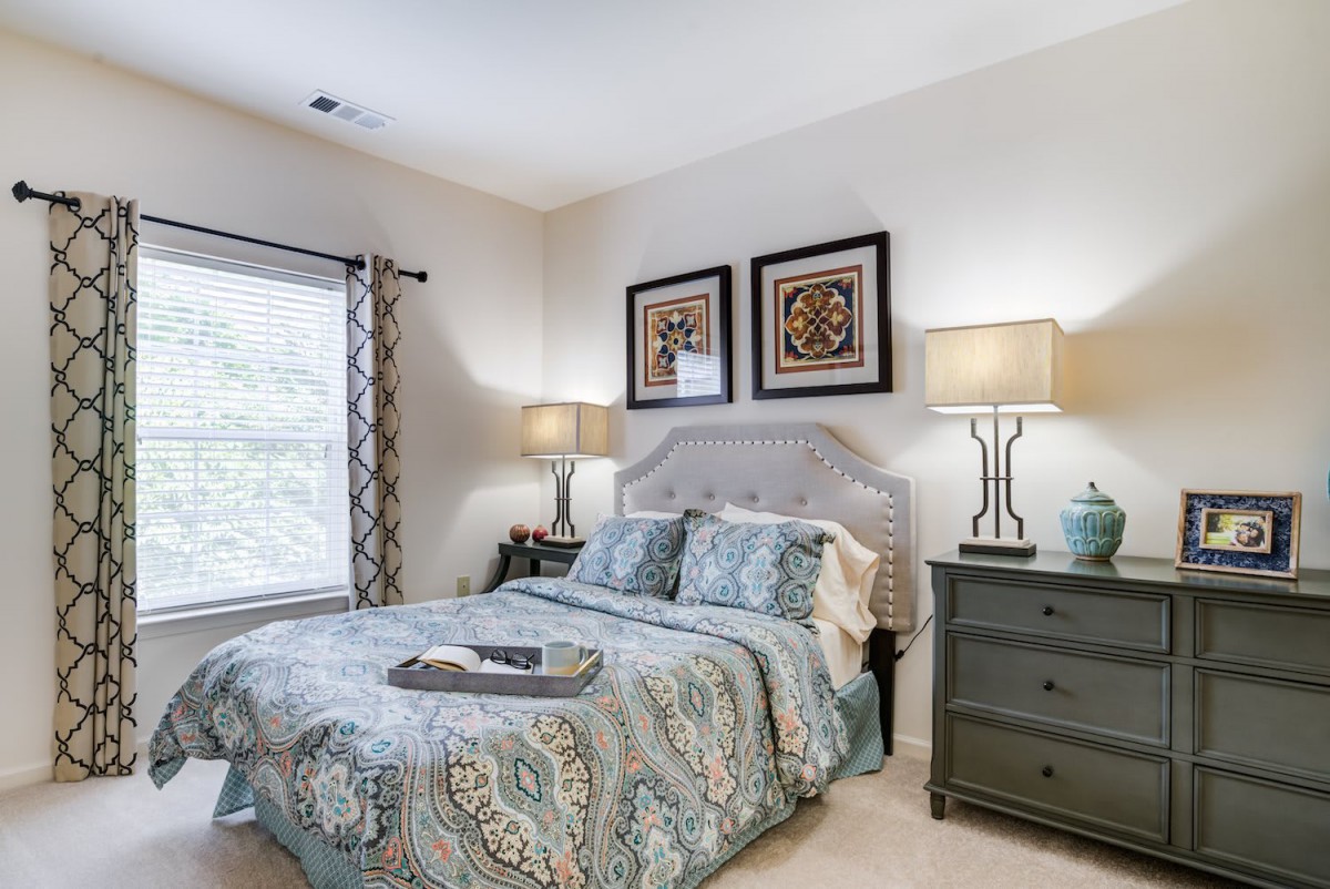 A cozy bedroom with a patterned bedspread and elegant decor.