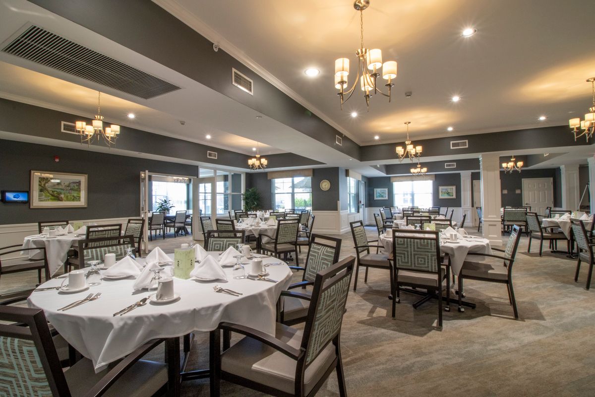 An elegant dining room with neatly arranged tables and chairs, set for a meal.