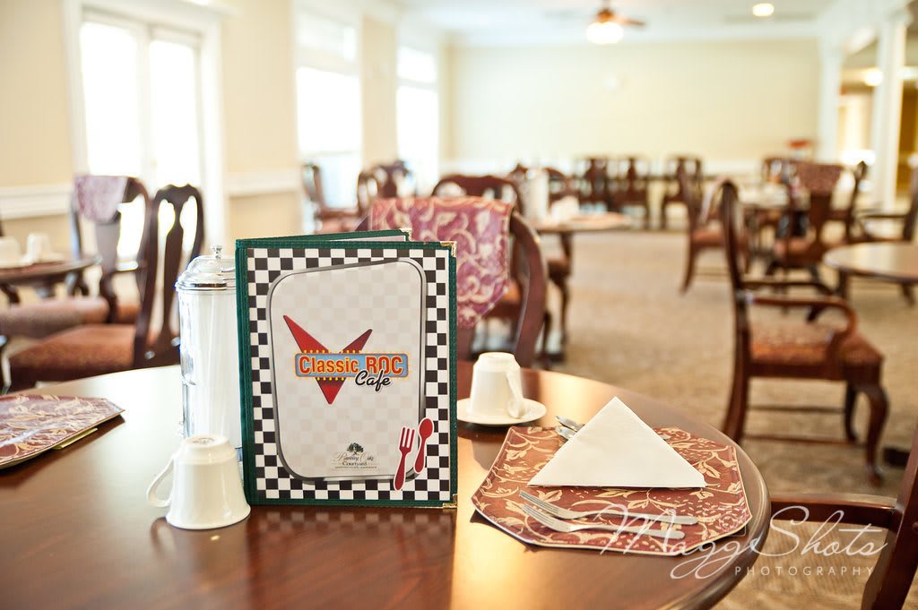 A cozy cafe interior with neatly arranged dining tables and a prominently displayed menu.