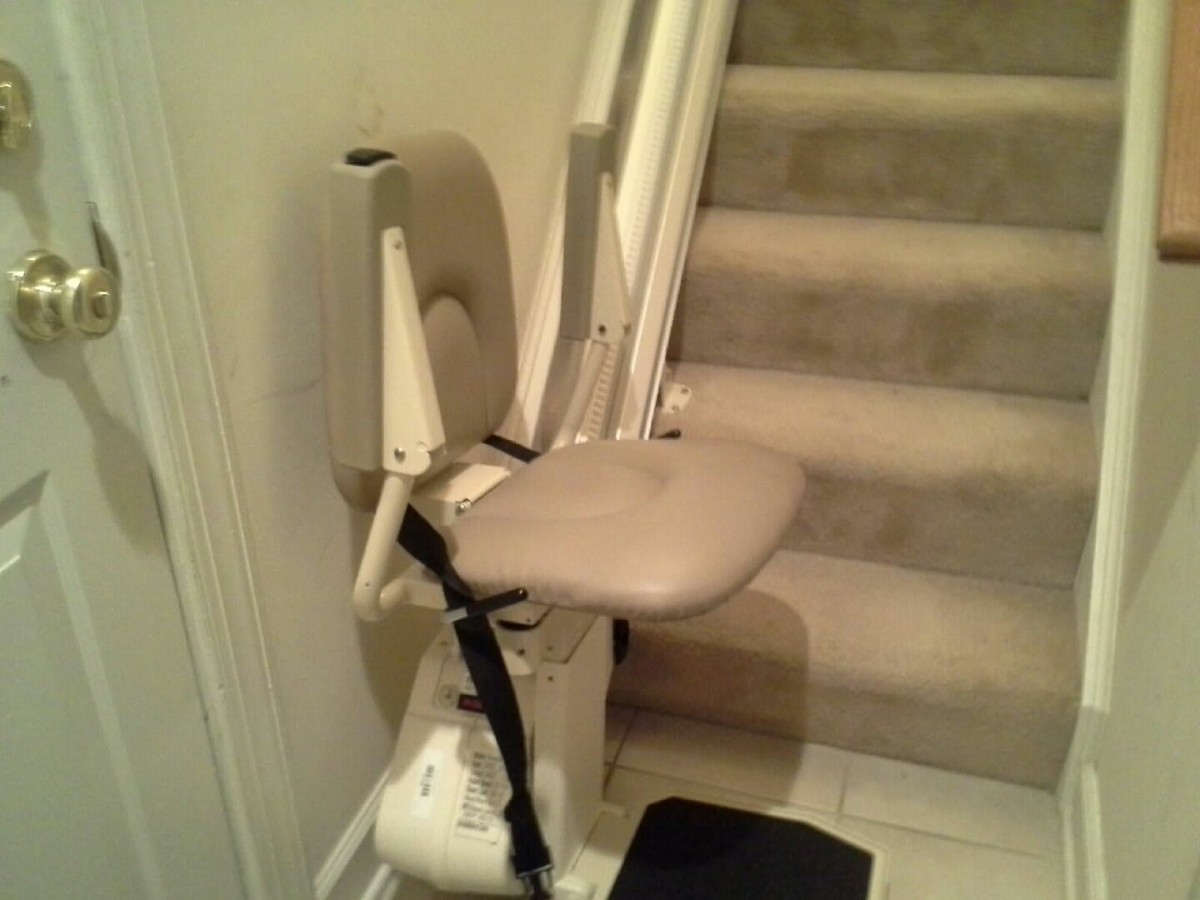 A stairlift installed beside a staircase, designed to assist individuals with mobility challenges.