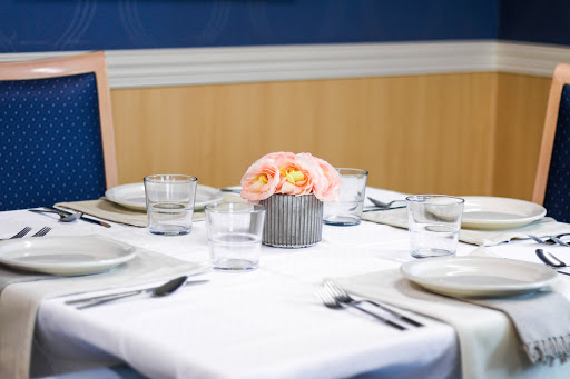 A beautifully arranged dining table featuring elegant glassware and a floral centerpiece.