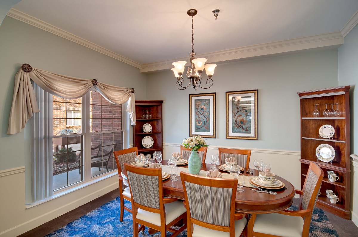 A cozy dining room with a wooden table, chairs, and elegant decor.