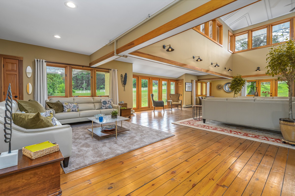 A spacious and modern living room featuring hardwood floors, ample natural light, and contemporary furniture.