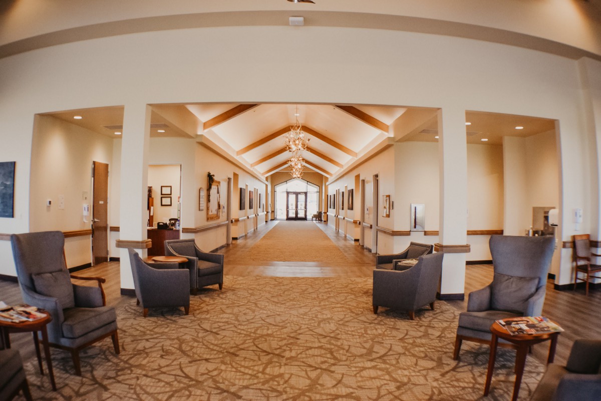 A modern hallway with seating areas and decorative lighting.