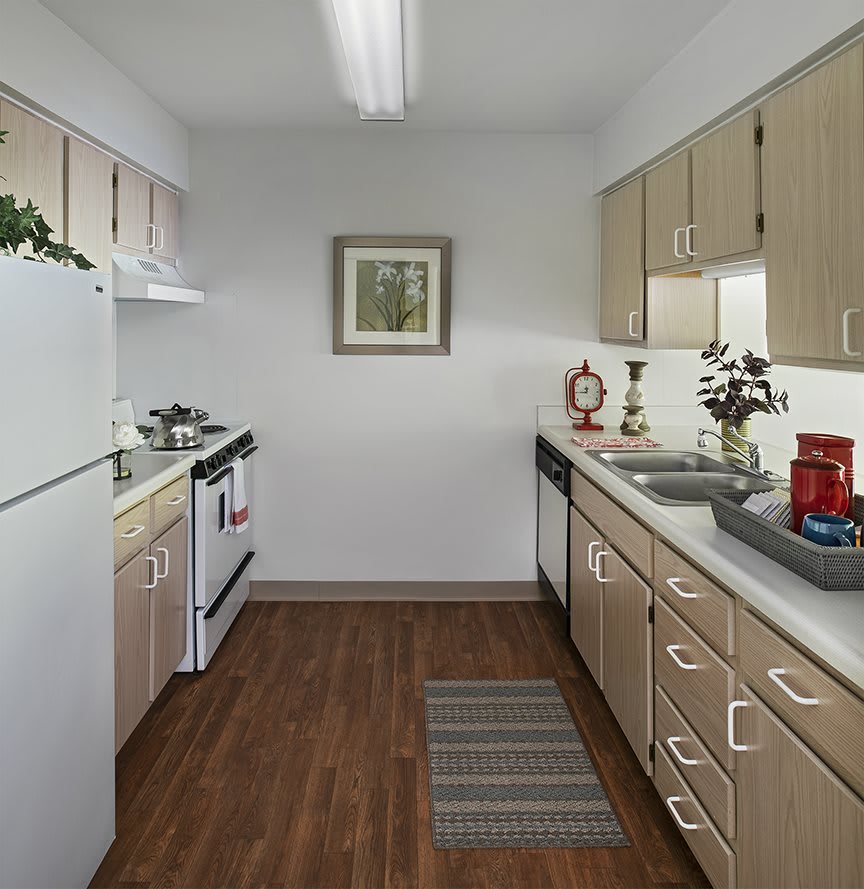 A modern kitchen with wooden cabinets, a stove, and a refrigerator, featuring ample countertop space.