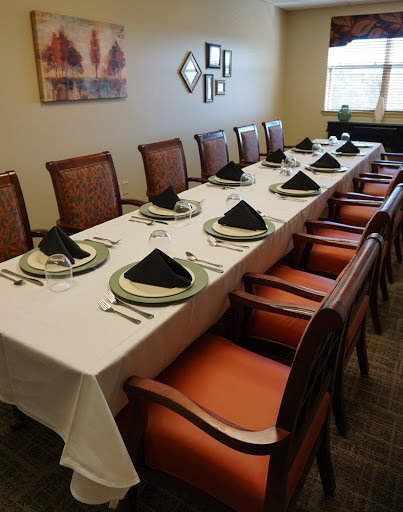 A well-set dining table ready for a formal meal, featuring elegant tableware and neatly arranged napkins.