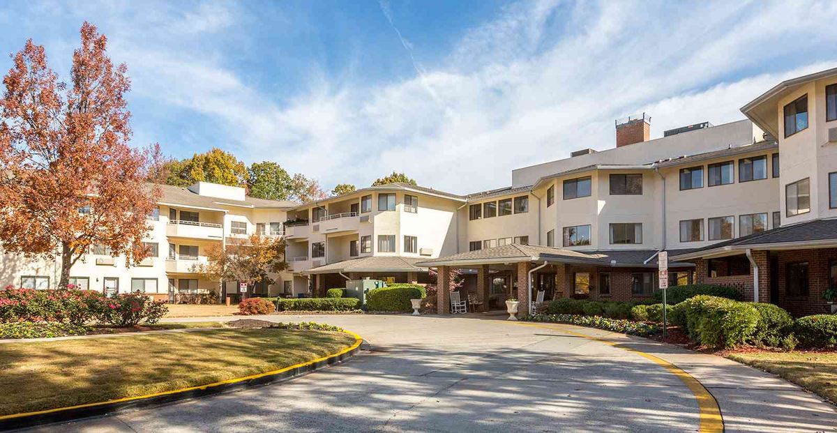 A sunny view of a modern residential building with well-kept landscaping.