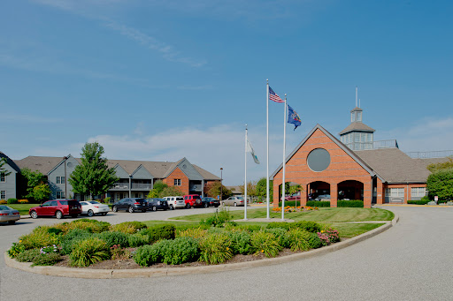 A sunny day showcasing a well-designed building with flags and landscaped greenery.