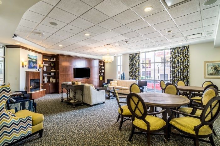 A modern living room with comfortable seating, a television, and large windows providing natural light.